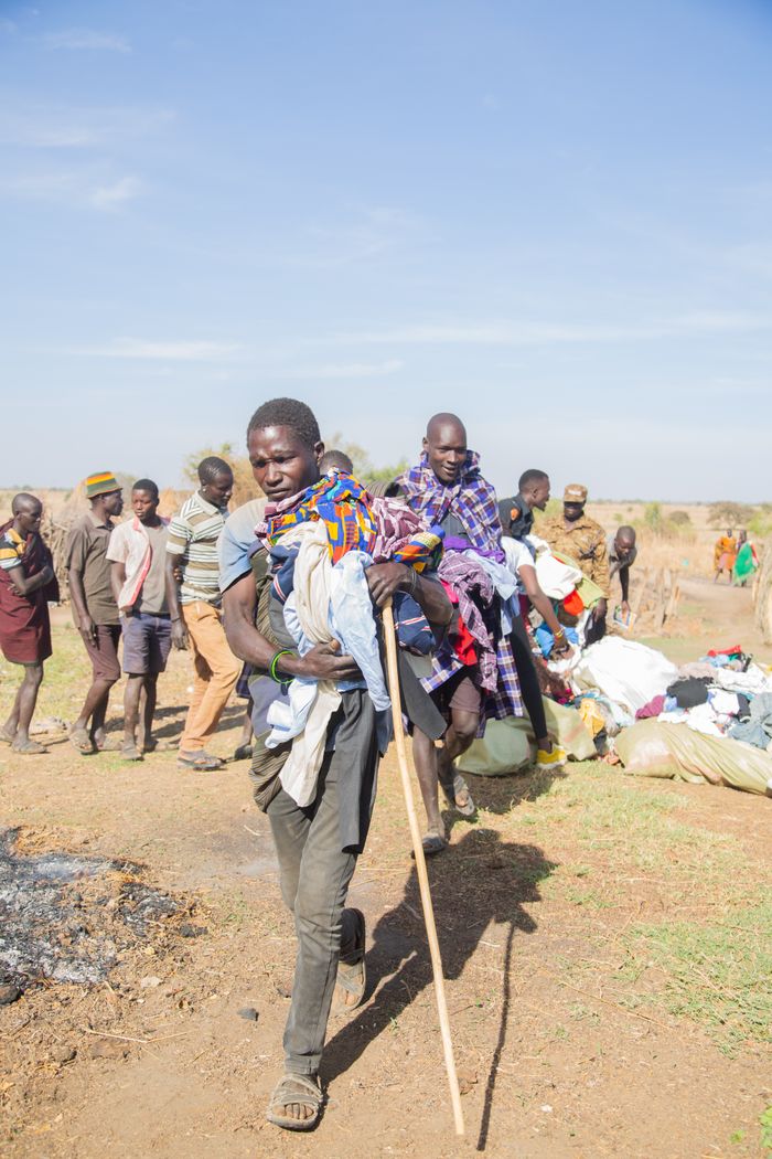 People gather outdoors for clothing distribution in an African village.
